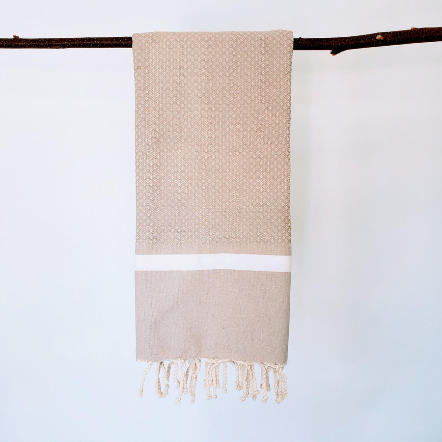  Lions Foot towel in sand color hanging from a branch